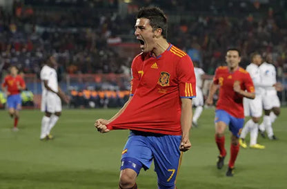 Soccer player in Spanish national team jersey celebrating on the field