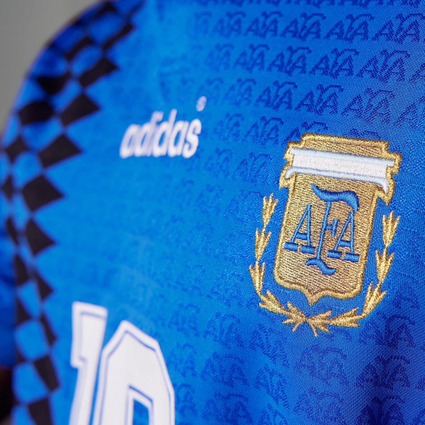 Close-up of a blue sports jersey with Adidas and AFA logos.